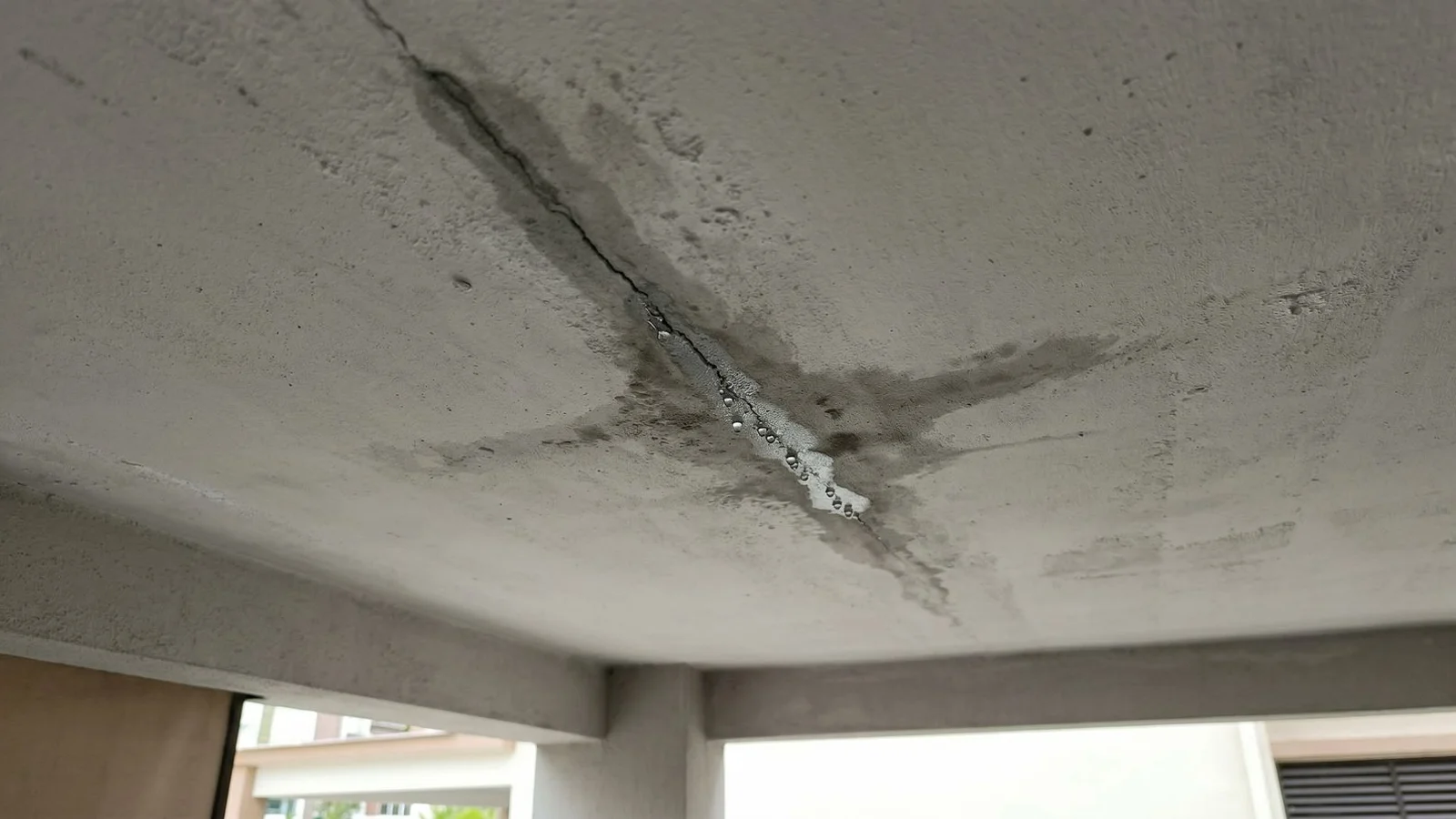 Leaking car porch slab underside showing wet crack before PU injection