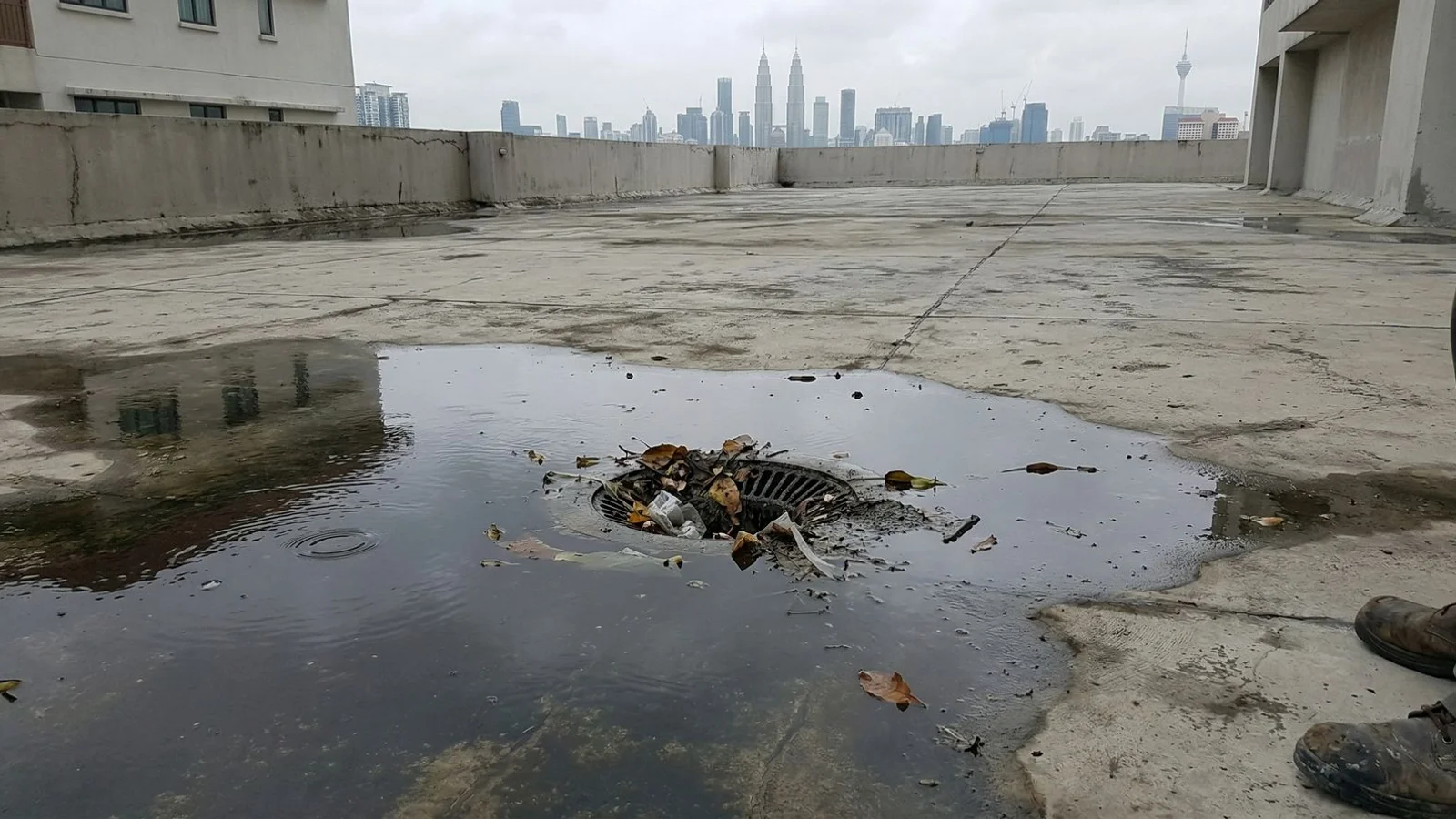 Ponding water on a flat concrete roof slab showing poor drainage